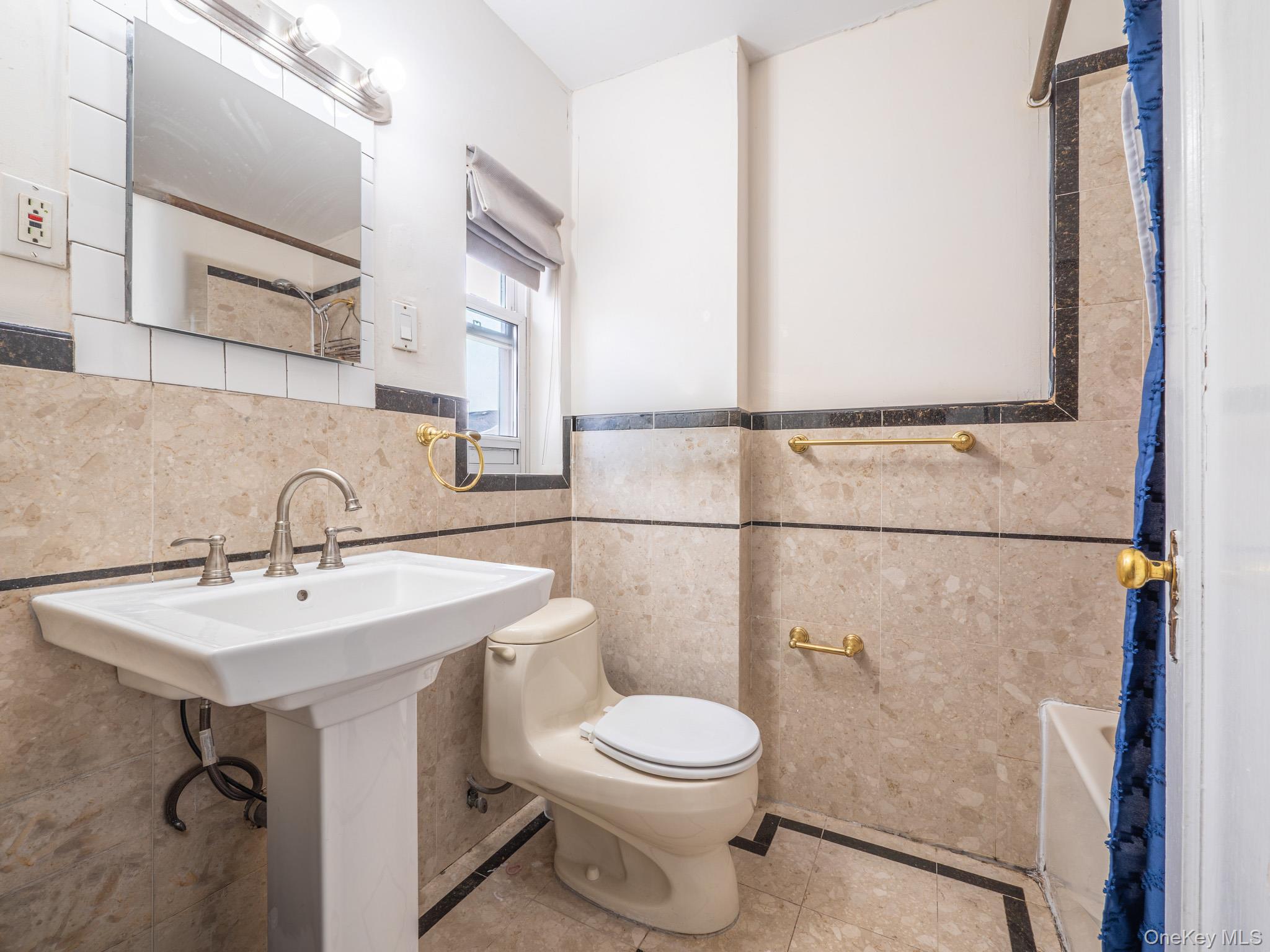 75-75 180th Street Queens, NY 11366 - Photo 20 of 48 a bathroom with a toilet sink and mirror