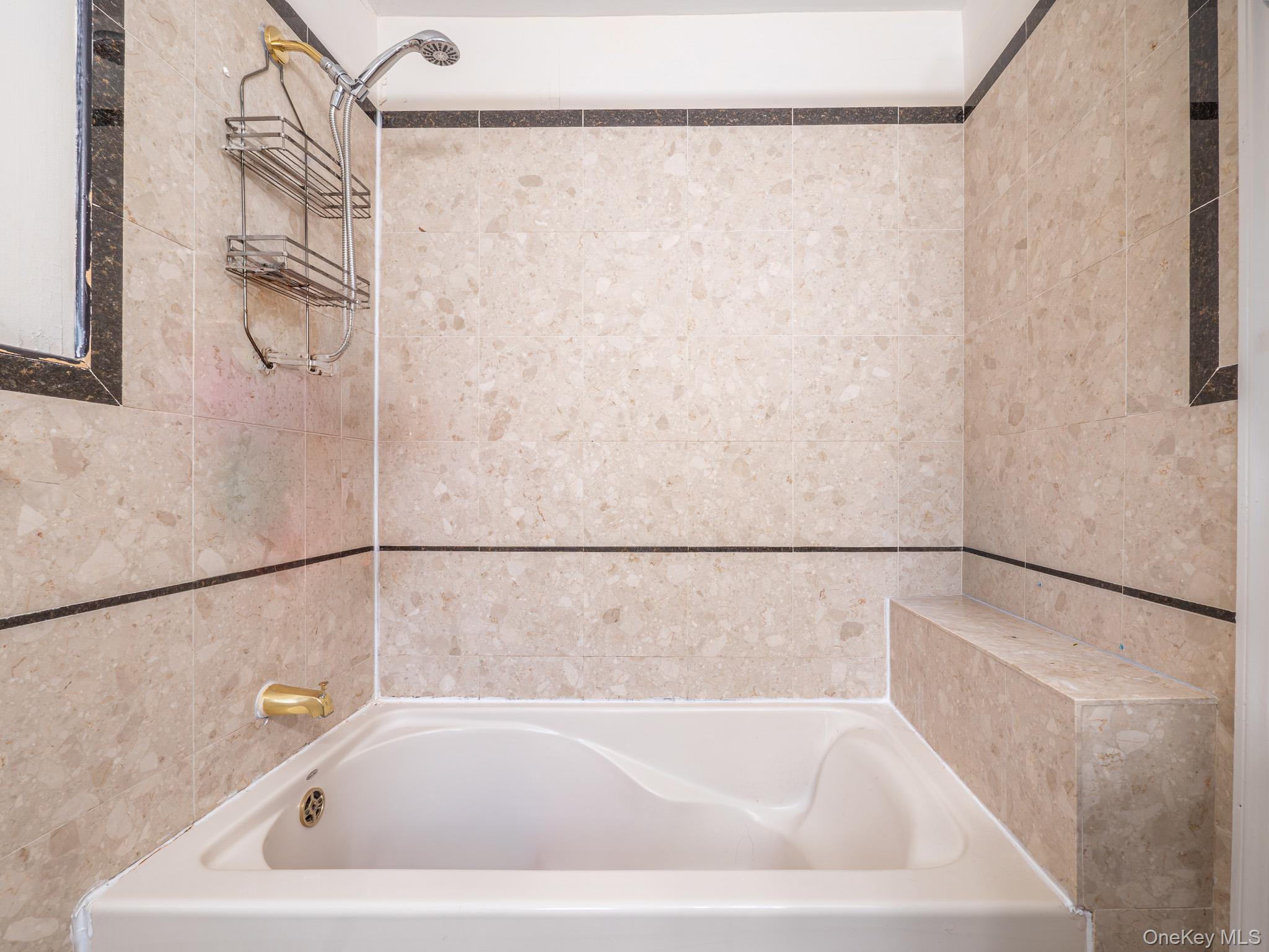 75-75 180th Street Queens, NY 11366 - Photo 21 of 48 a white bath tub sitting in a bathroom
