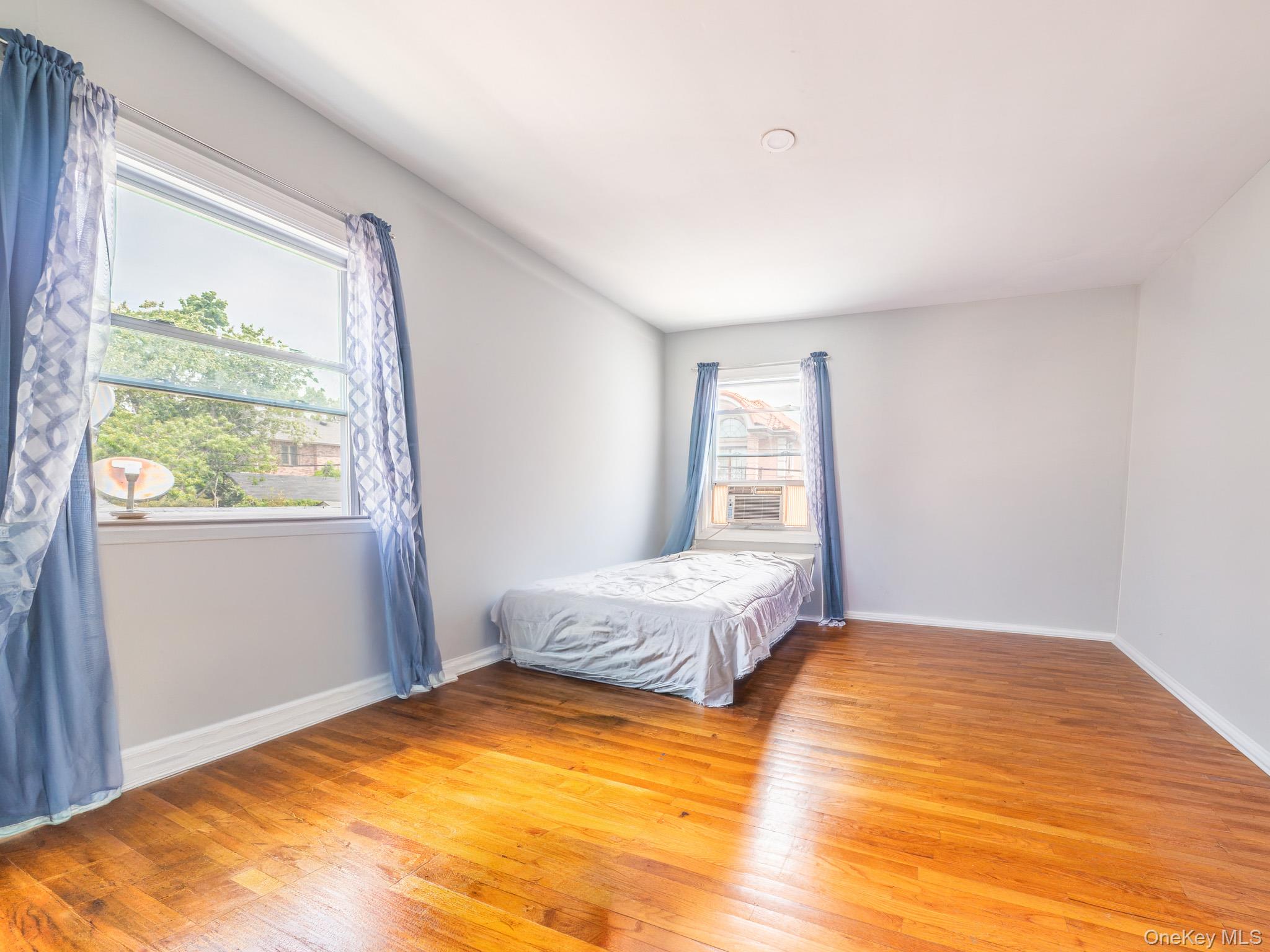 75-75 180th Street Queens, NY 11366 - Photo 22 of 48 a bedroom with a bed and wooden floor