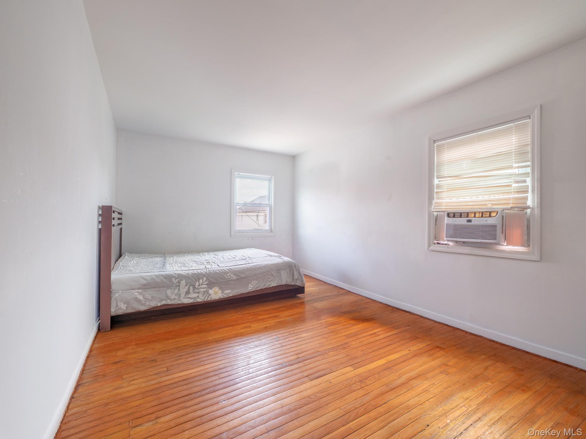 75-75 180th Street Queens, NY 11366 - Photo 24 of 48 a bedroom with a bed and wooden floor