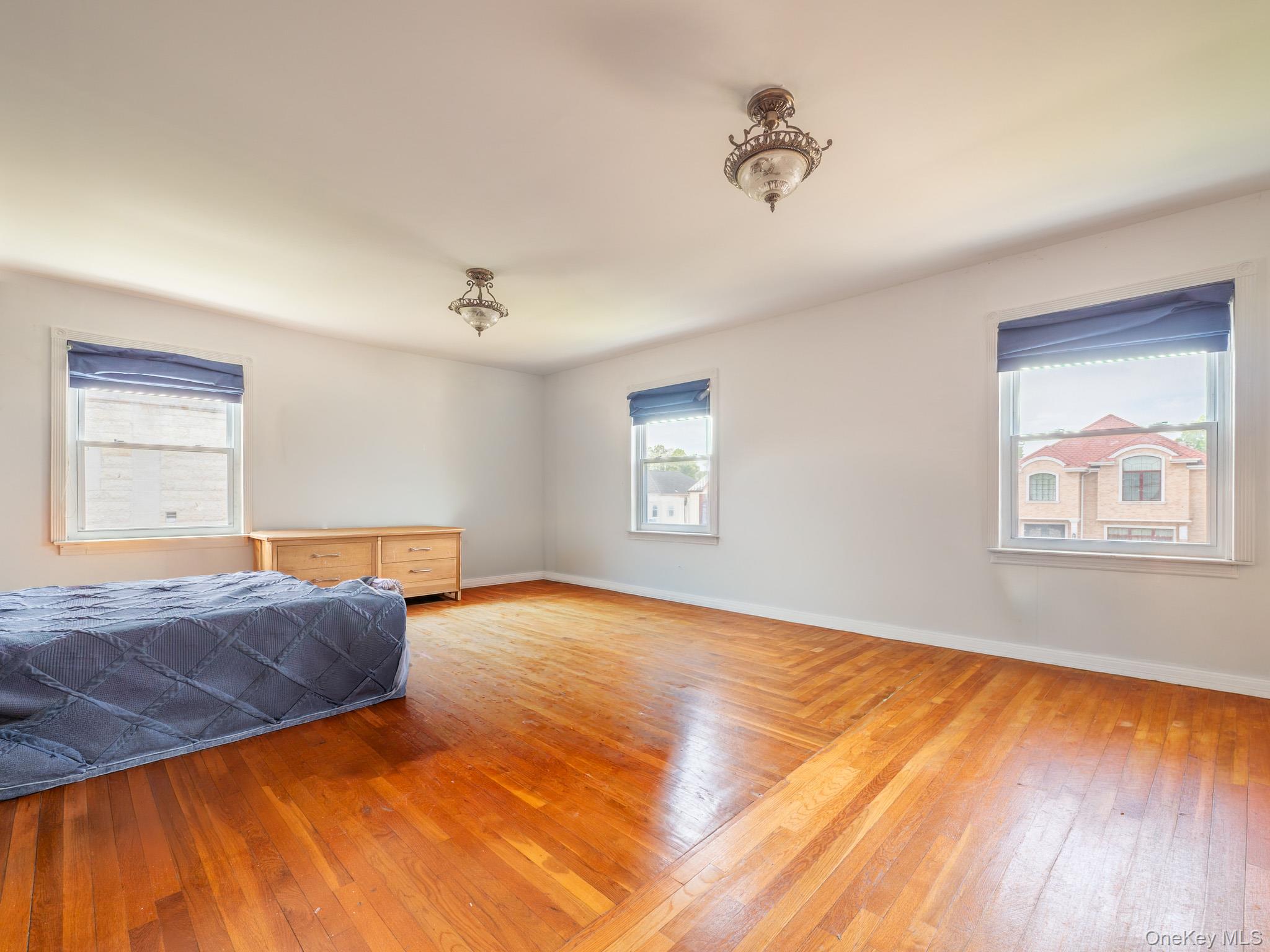 75-75 180th Street Queens, NY 11366 - Photo 27 of 48 a view of an empty room with window and wooden floor