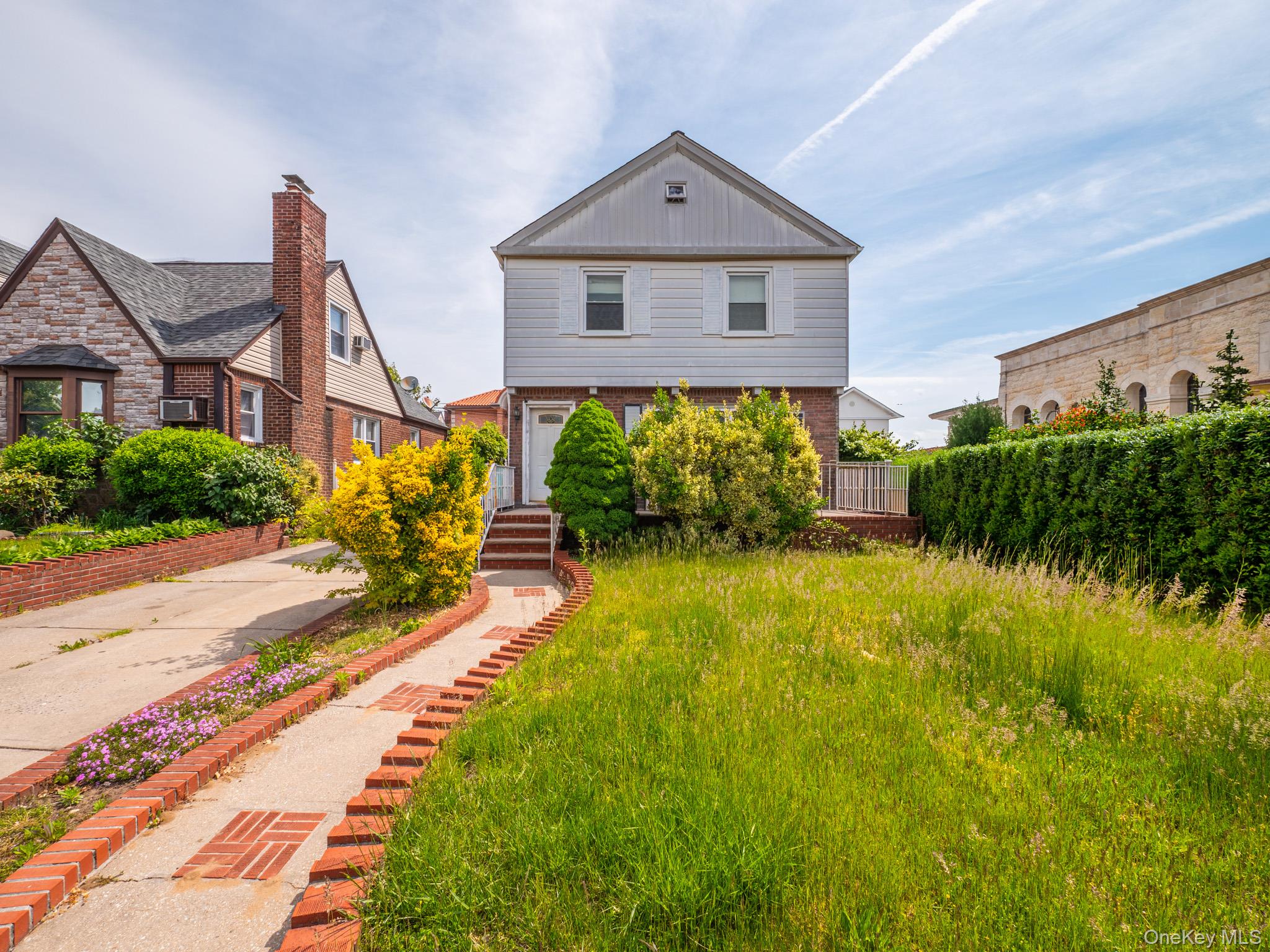 75-75 180th Street Queens, NY 11366 - Photo 3 of 48 a front view of a house with garden