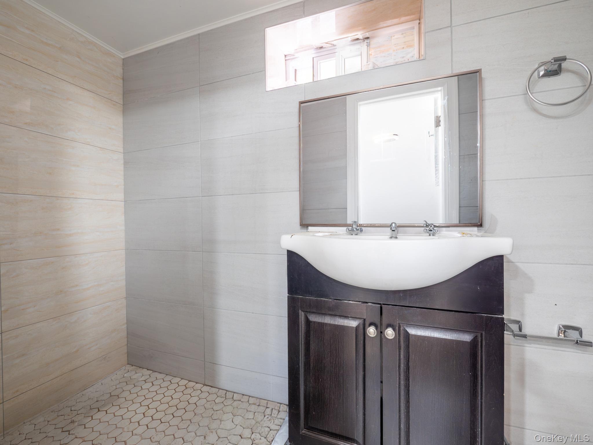 75-75 180th Street Queens, NY 11366 - Photo 34 of 48 a bathroom with a sink a mirror and a toilet