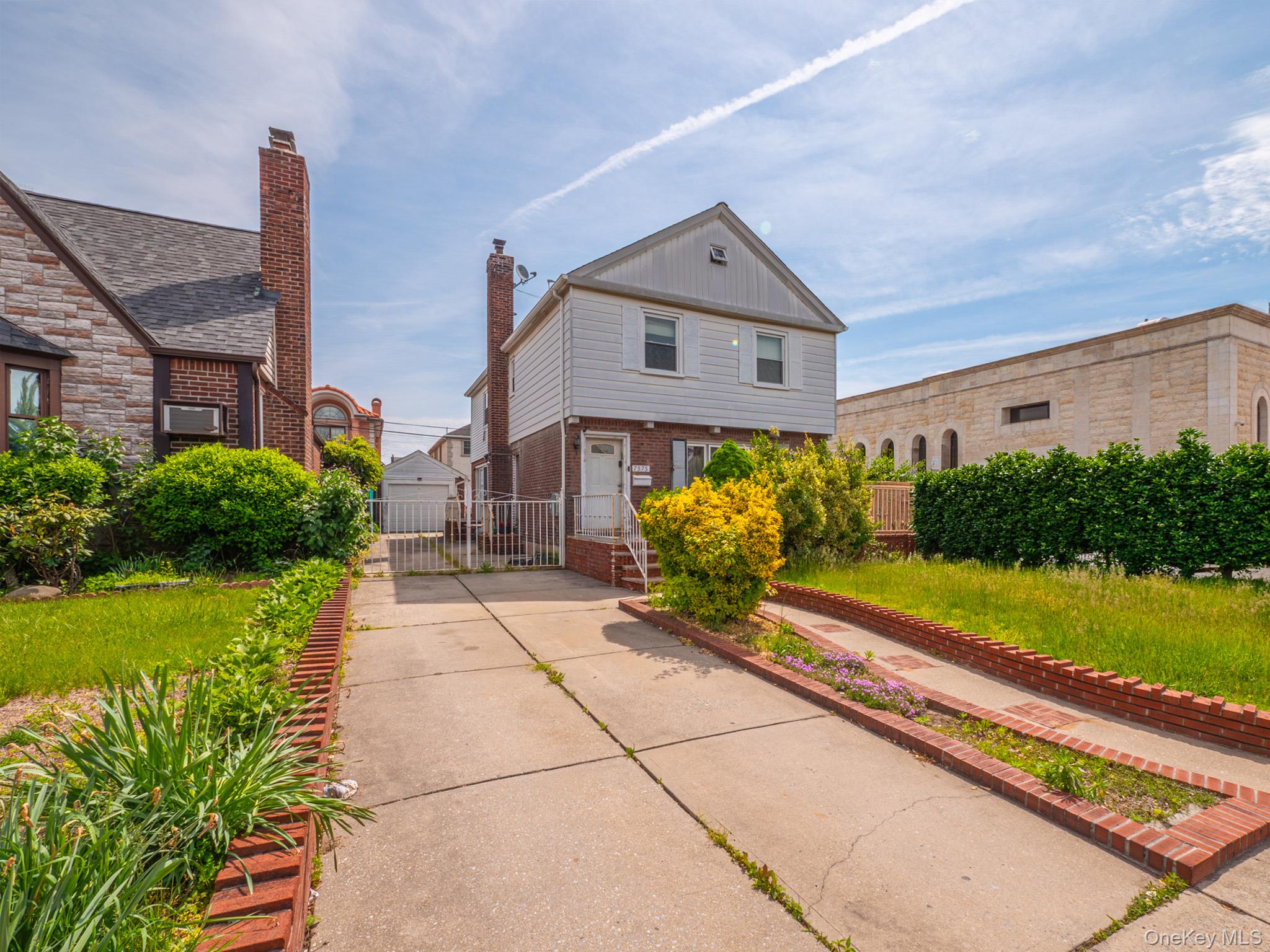 75-75 180th Street Queens, NY 11366 - Photo 4 of 48 a front view of a house with garden