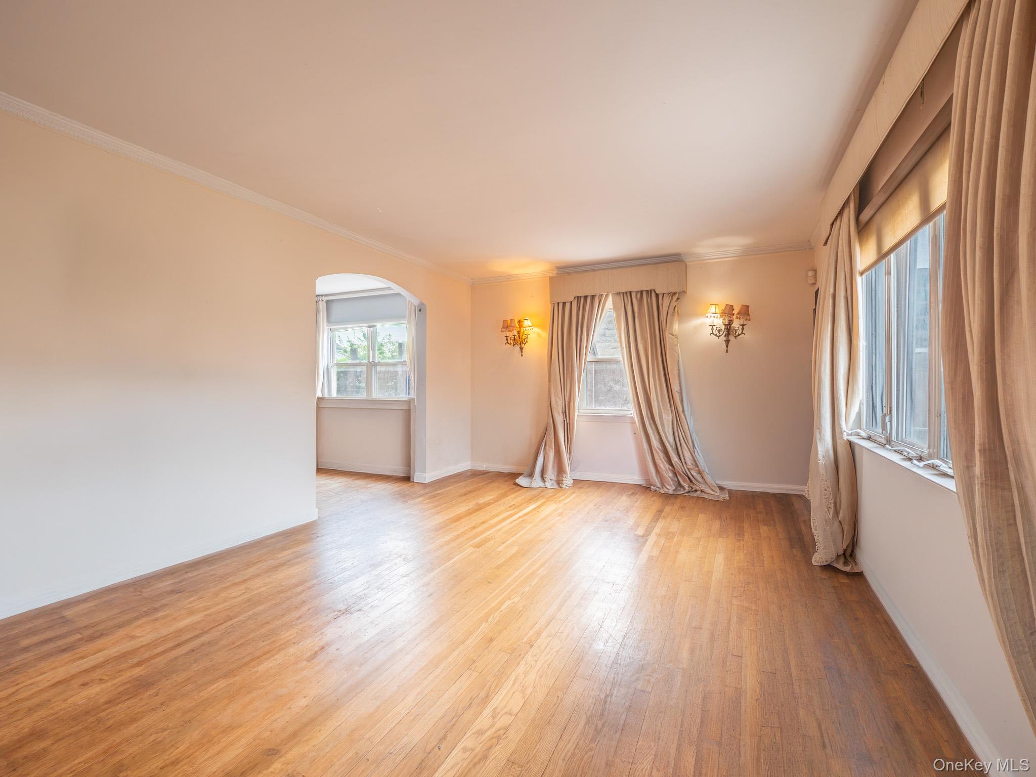 75-75 180th Street Queens, NY 11366 - Photo 6 of 48 an empty room with wooden floor and windows
