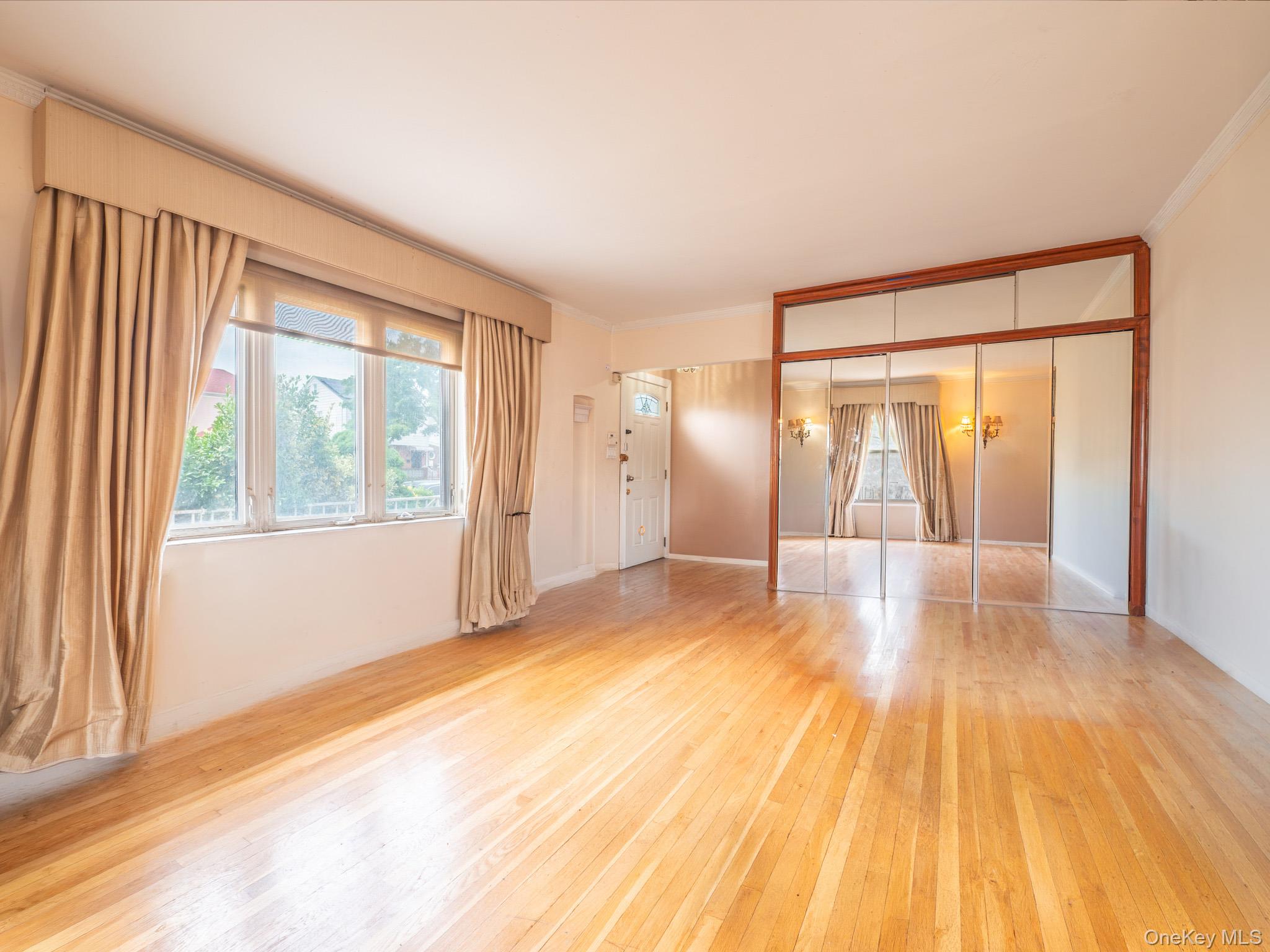 75-75 180th Street Queens, NY 11366 - Photo 7 of 48 a view of empty room with wooden floor and fan