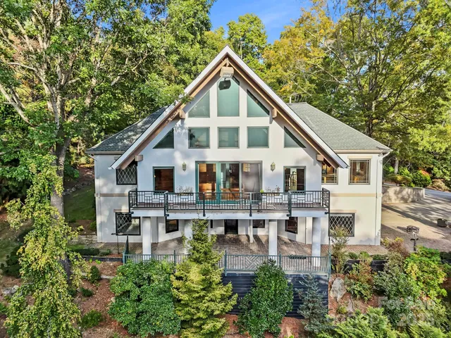 a view of a white house with large windows and plants