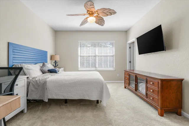 a bedroom with a bed a flat screen tv and a window