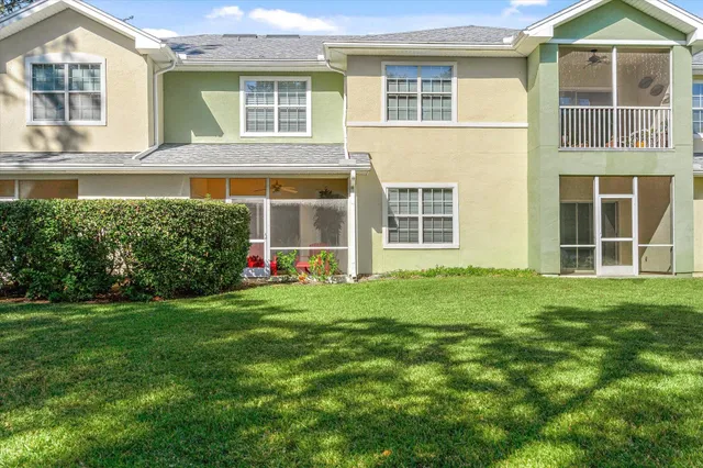 a view of a house with a big yard and large trees