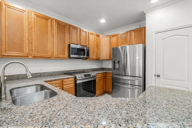 a kitchen with granite countertop a refrigerator sink and microwave
