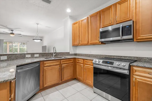 a kitchen with stainless steel appliances granite countertop a stove microwave and sink