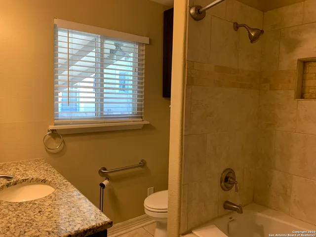 a bathroom with a granite countertop sink toilet and shower