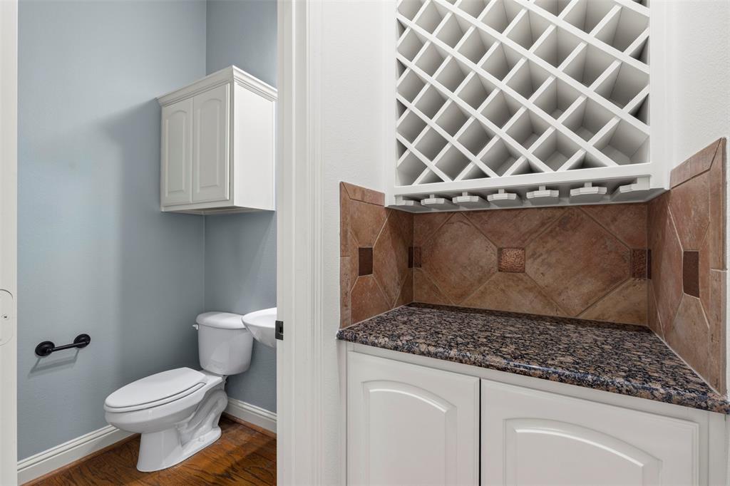8813 Tudor Place Dallas, TX 75228 - Photo 11 of 27 a bathroom with a granite countertop sink and a toilet