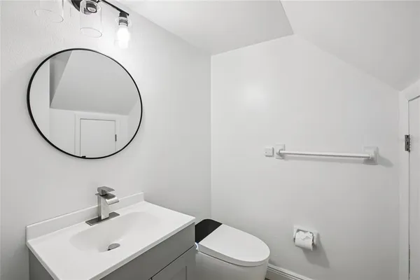 an empty room with wooden floor and ceiling fan