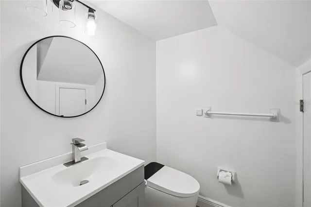 an empty room with wooden floor and ceiling fan