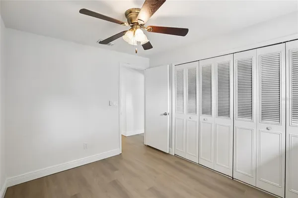 a view of empty room with wooden floor