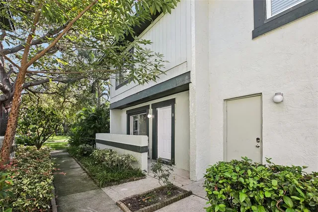 an empty room with wooden floor a ceiling fan and windows