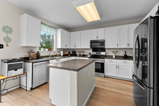 a kitchen with white cabinets and black stainless steel appliances