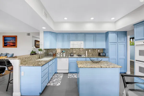 a kitchen with stainless steel appliances kitchen island granite countertop a table and chairs in it