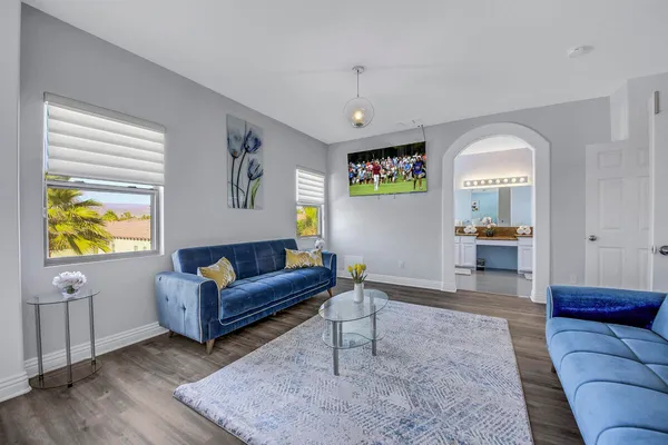 a living room with furniture and a wooden floor