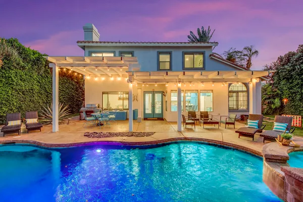 a front view of a house with swimming pool garden and patio