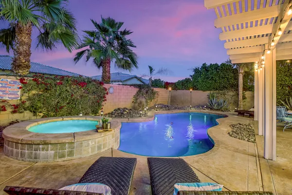 a view of a backyard with swimming pool and furniture