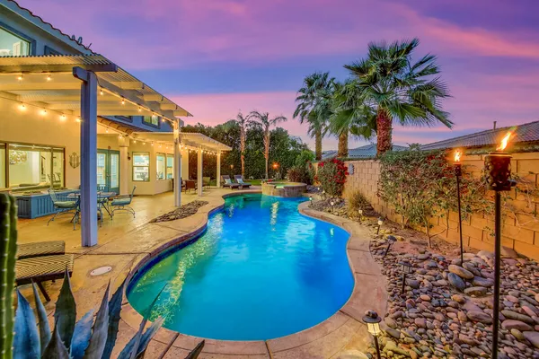 a view of a chair and table in backyard of the house