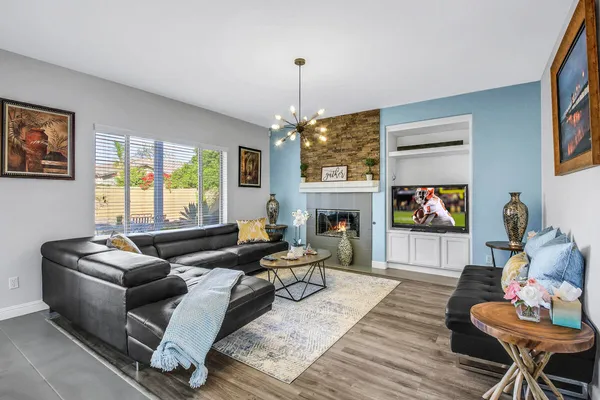 a living room with furniture a flat screen tv and a fireplace