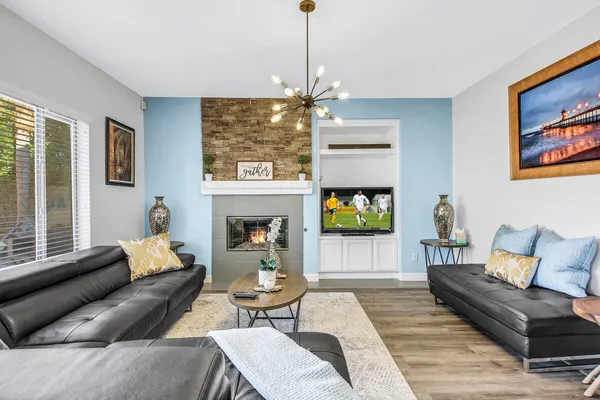 a living room with furniture a flat screen tv and a fireplace