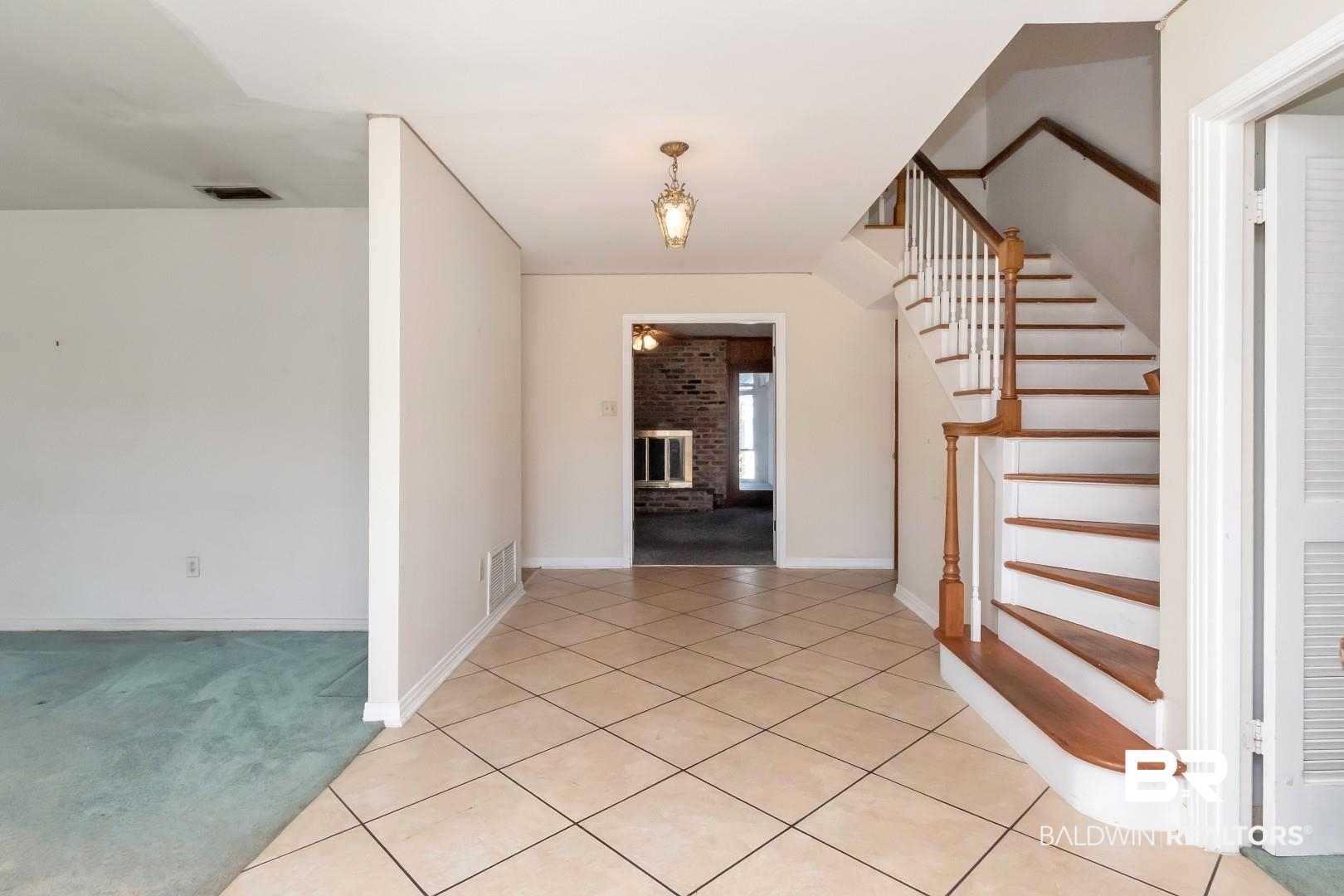 4543 Kingsway Drive Mobile, AL 36608 - Photo 3 of 28 Entrance foyer with stairs, a fireplace, visible vents, and light colored carpet