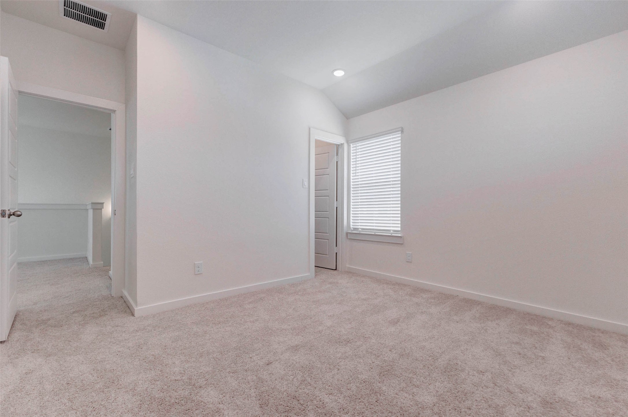 1206 Hemet Court Rosharon, TX 77583 - Photo 16 of 21 Bright secondary bedroom with neutral carpet, clean white walls, recessed lighting, and a window bringing in natural light. The room offers a comfortable layout with easy access to the nearby hallway, making it a great option for a guest bedroom, child’s room, home office, or quiet personal retreat.