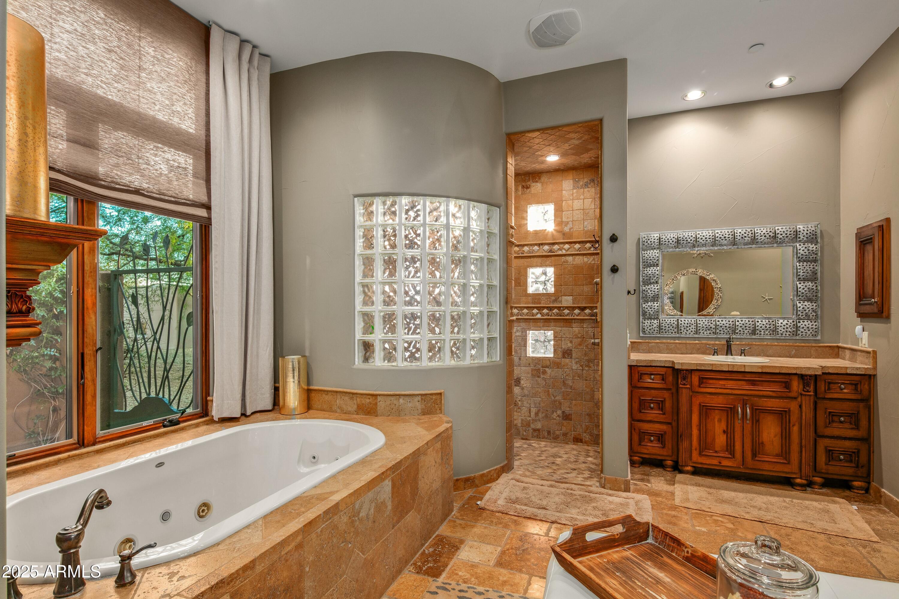 9533 East Rising Sun Drive Scottsdale, AZ 85262 - Photo 22 of 46 a bathroom with a tub a sink and a large window