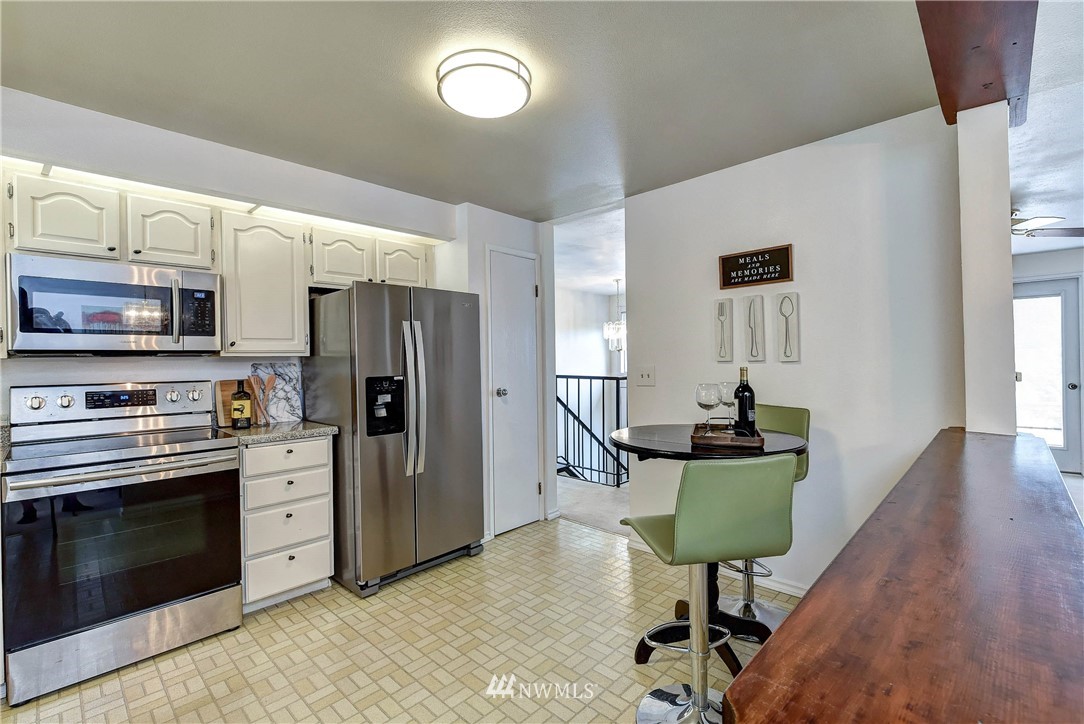22708 3rd Avenue Southeast Bothell, WA 98021 - Photo 15 of 26 a kitchen with stainless steel appliances kitchen island granite countertop a stove a refrigerator and a microwave