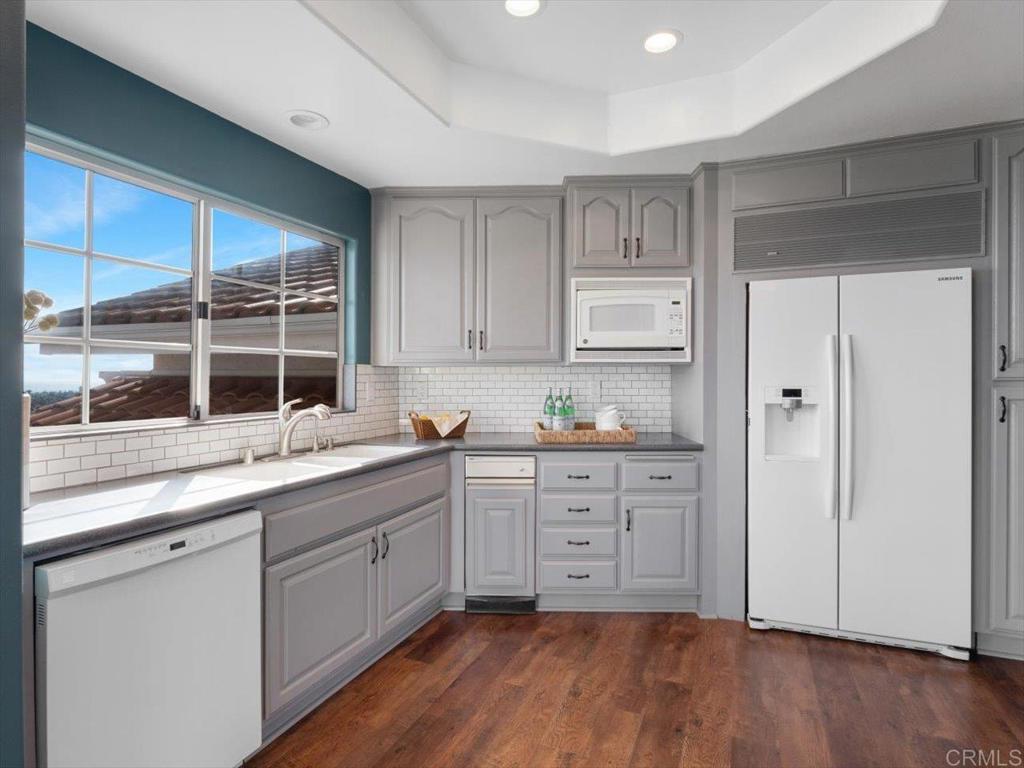 1780 Laurel Road Oceanside, CA 92054 - Photo 11 of 46 a kitchen with granite countertop white cabinets and white appliances
