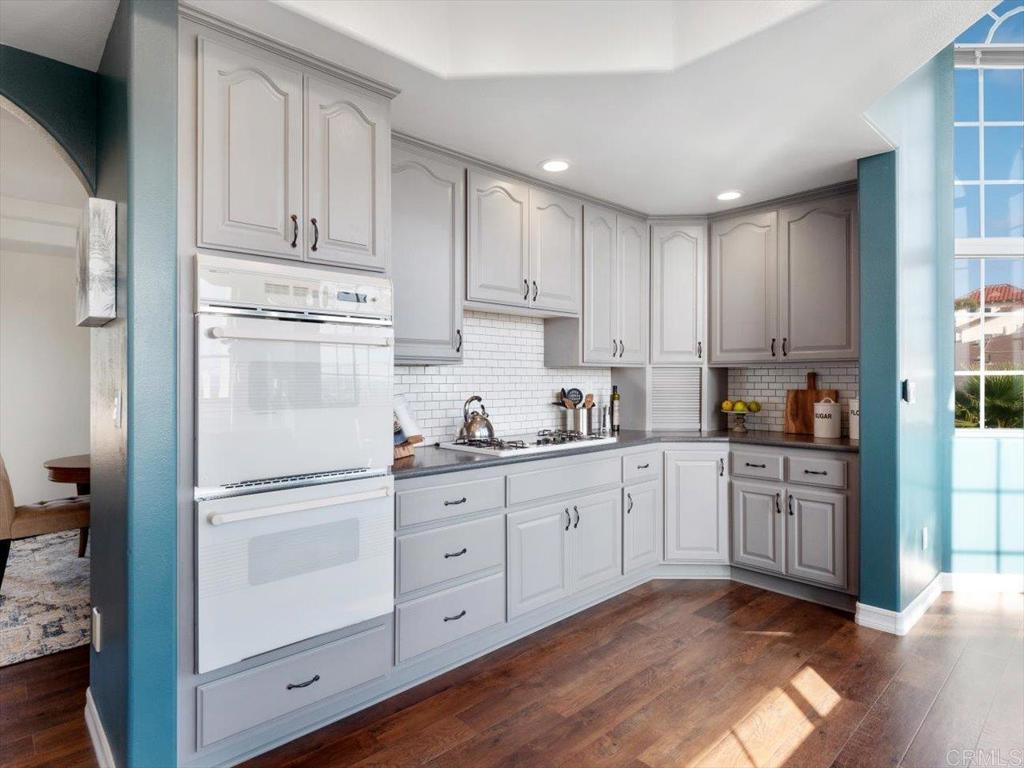 1780 Laurel Road Oceanside, CA 92054 - Photo 12 of 46 a kitchen with cabinets stainless steel appliances and wooden floor