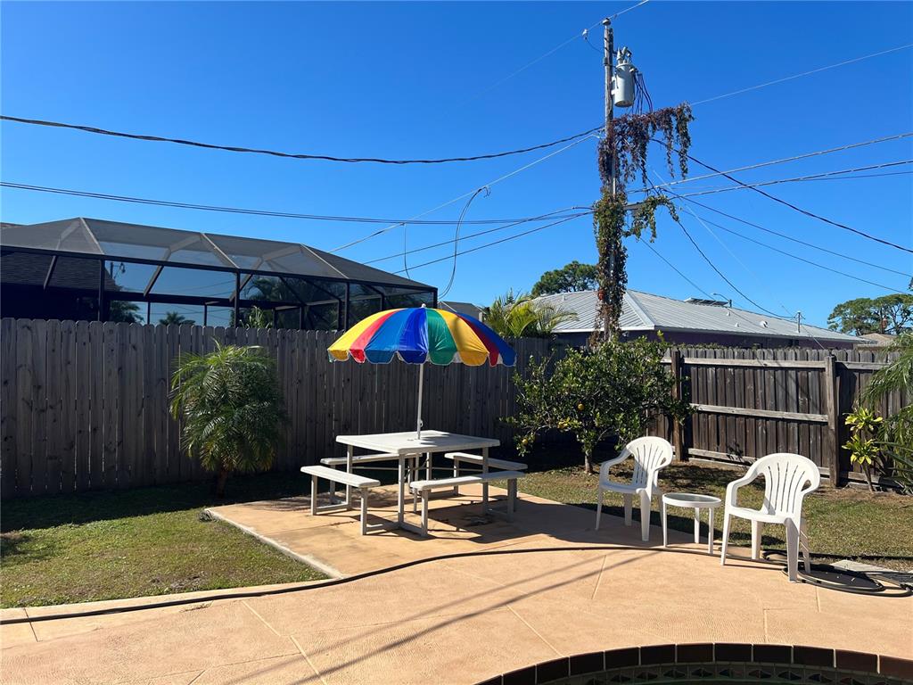 1228 Nantucket Road Venice, FL 34293 - Photo 12 of 32 a view of a patio with a table and chairs under an umbrella