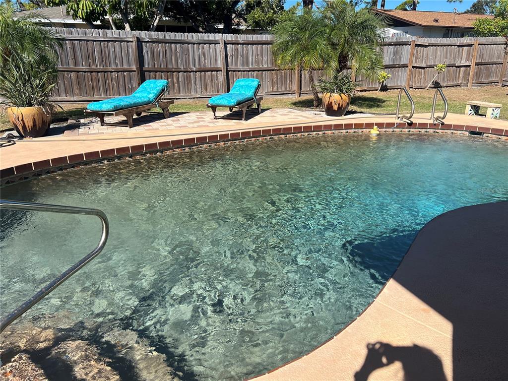 1228 Nantucket Road Venice, FL 34293 - Photo 14 of 32 a view of a swimming pool with a patio and a garden