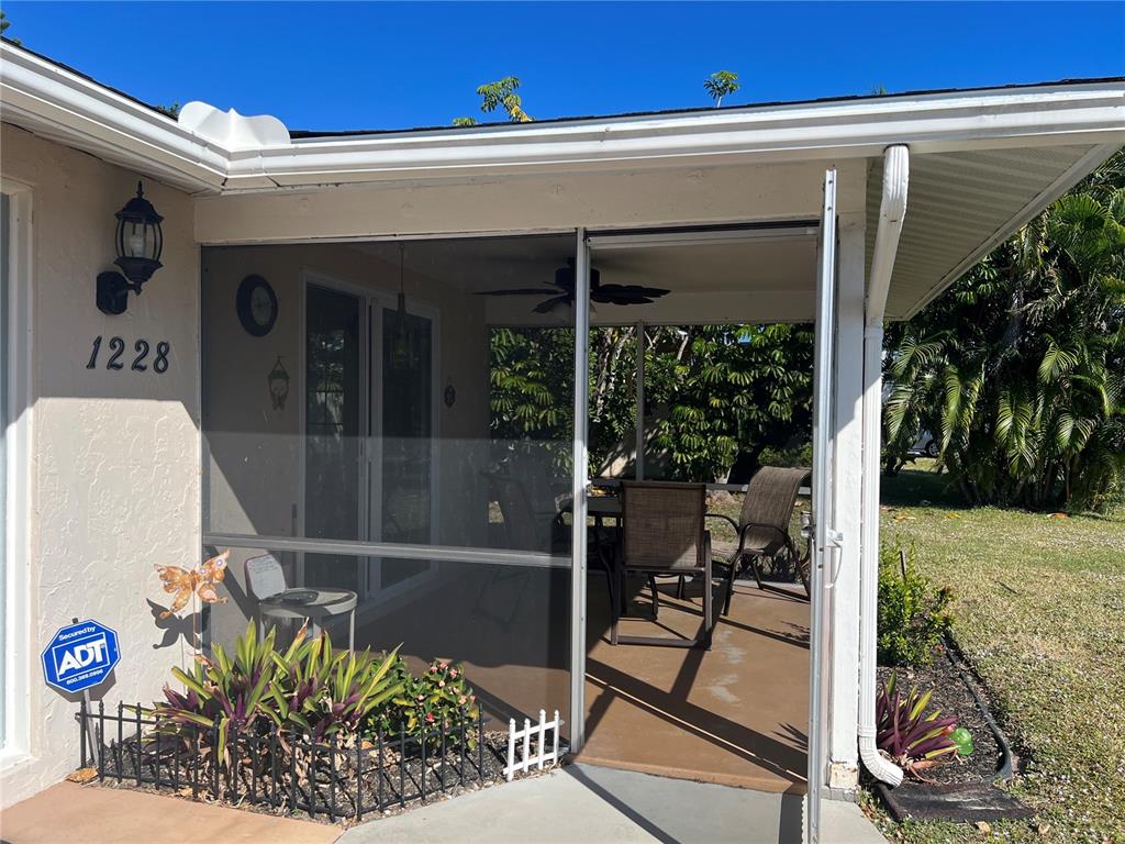 1228 Nantucket Road Venice, FL 34293 - Photo 5 of 32 a view of a patio with table and chairs potted plants with wooden floor