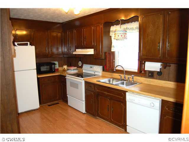 17401 Elko Road Petersburg, VA 23803 - Photo 4 of 12 a kitchen with a sink refrigerator and cabinets