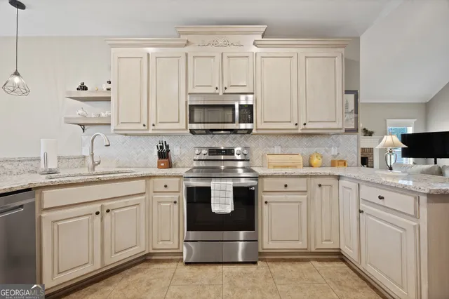 a kitchen with white cabinets sink and stainless steel appliances