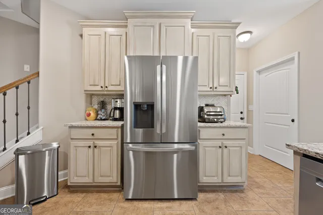 a kitchen with cabinets stainless steel appliances and a refrigerator