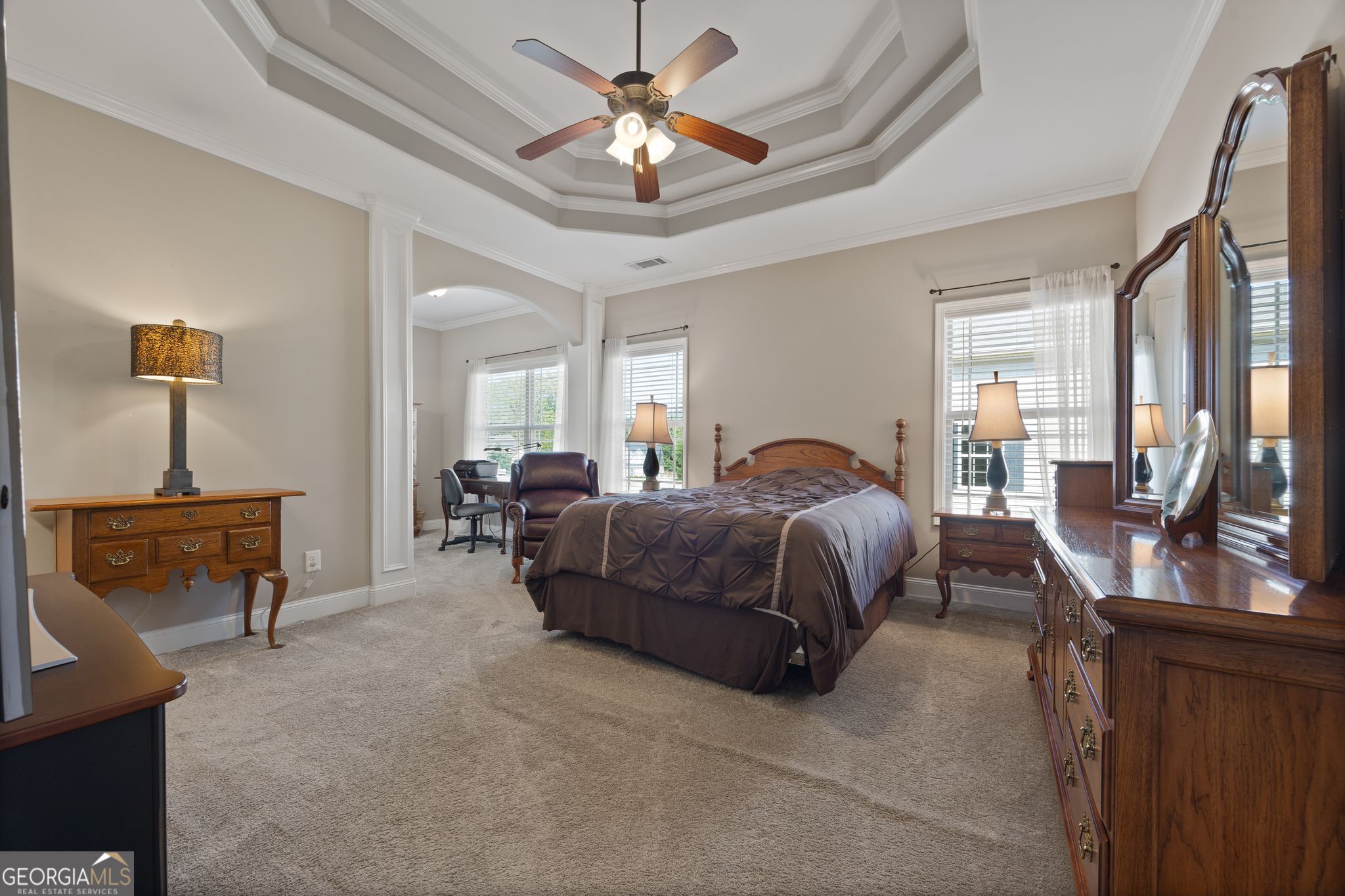 107 Sweet Bay Circle Milner, GA 30257 - Photo 16 of 31 a spacious bedroom with a bed a chandelier and window