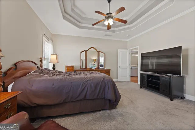 a spacious bedroom with a bed and a flat screen tv