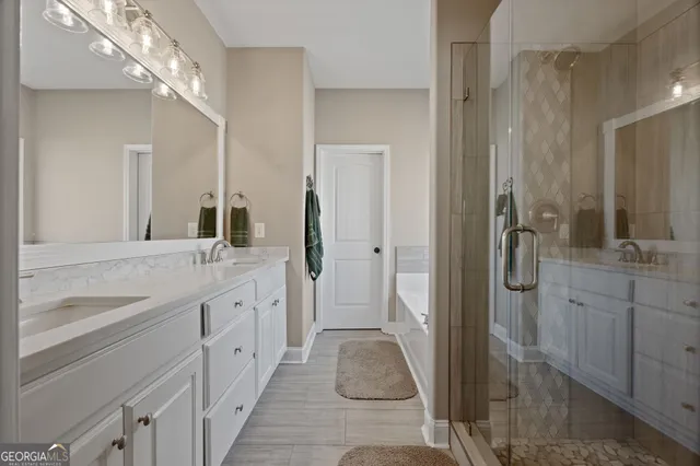 a spacious bathroom with a double vanity sink a mirror and a shower