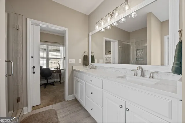 a spacious en suite bathroom with double sink and a mirror