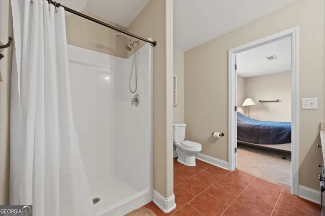 a bathroom with a toilet and a shower