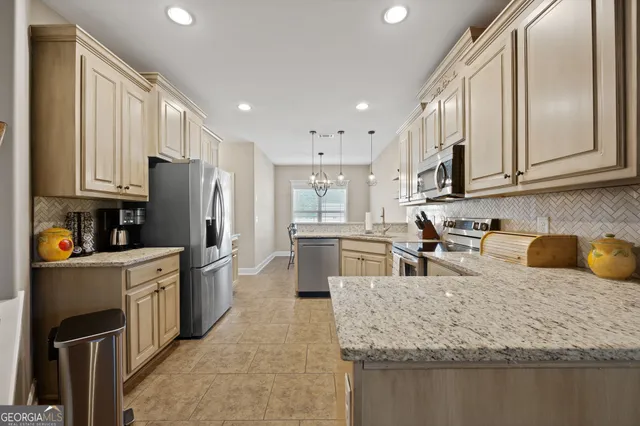 a kitchen with stainless steel appliances granite countertop a sink refrigerator and cabinets