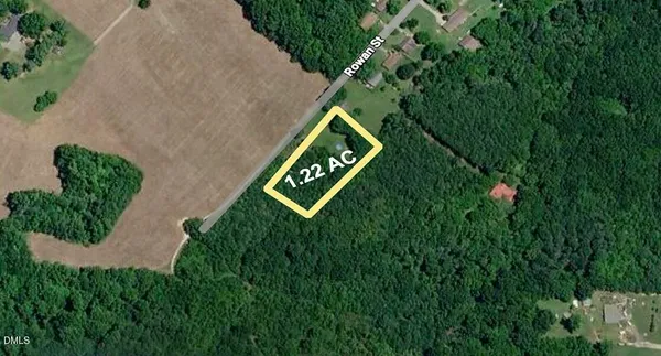 a sign that is sitting in the grass next to a road