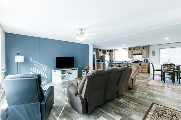 a kitchen with stainless steel appliances kitchen island granite countertop a dining table chairs and granite counter tops