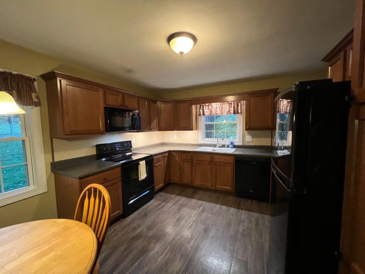 1523 Bore Auger Road Blue Ridge, VA 24064 - Photo 8 of 34 a kitchen with stainless steel appliances granite countertop a refrigerator a stove a sink dishwasher and microwave with wooden floor